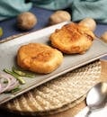 Close-up of crispy Indian Aloo Bonda served with sliced onions and chillies.