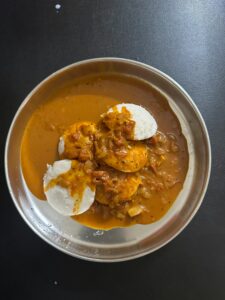 A top view of a traditional South Indian idli sambar meal served on a silver plate.