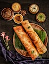 Delicious traditional dosa served with a variety of Indian chutneys and sambar on banana leaves.
