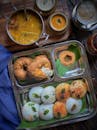 Traditional South Indian breakfast featuring idli, vada, sambar, and chutney on a metal plate.