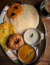 Top view of a traditional South Indian breakfast with dosa, chutneys, and filter coffee.